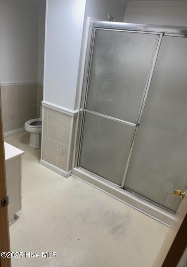 714 Walnut St, Laurinburg, NC 28352 - bathroom with toilet, a shower with shower door, vanity, and wainscoting