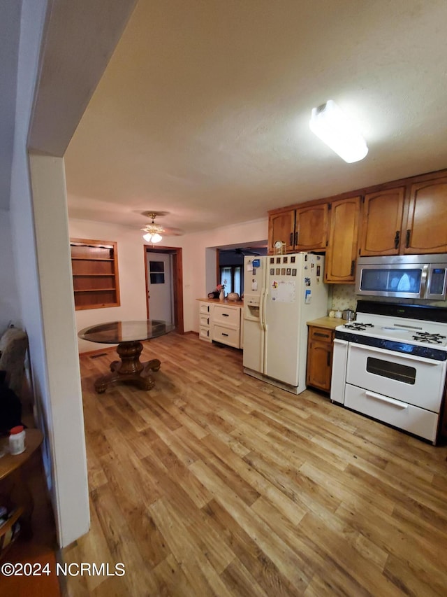 kitchen featuring ceiling fan, light hardwood / wood-style floors, white appliances, and backsplash