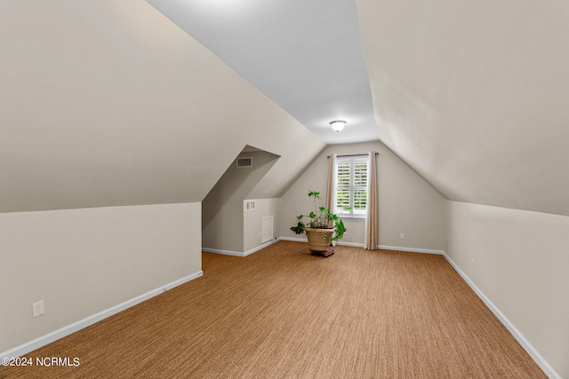 additional living space featuring lofted ceiling and light colored carpet