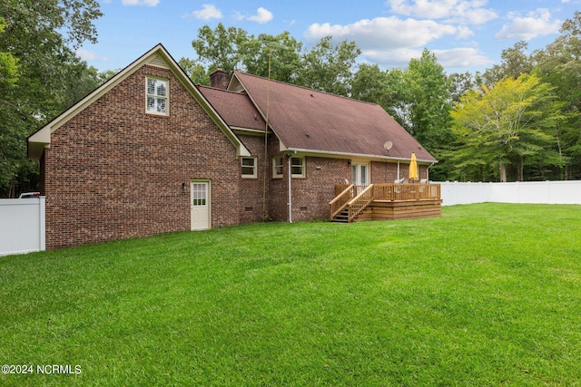 rear view of house with a yard and a deck