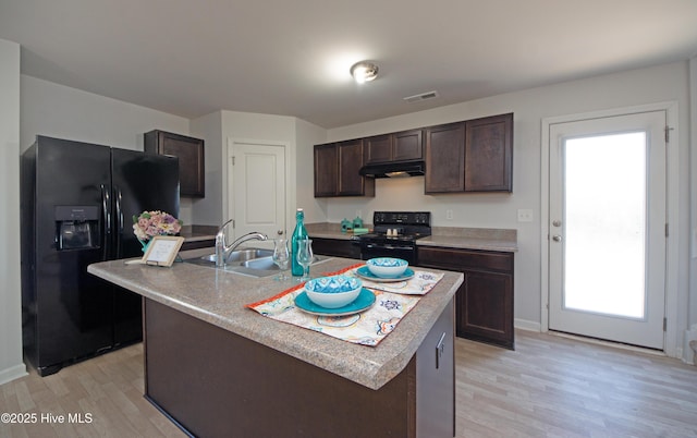 kitchen featuring dark brown cabinets, light hardwood / wood-style floors, a kitchen island with sink, and black appliances