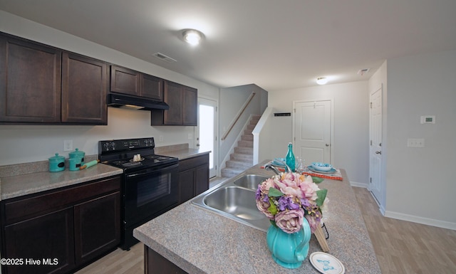 kitchen featuring black / electric stove, dark brown cabinets, light hardwood / wood-style floors, and sink