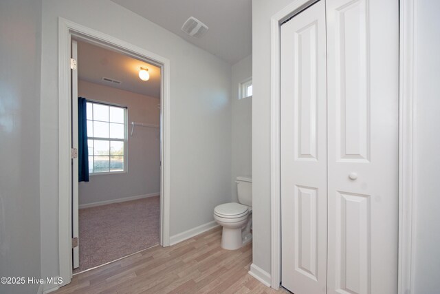 bathroom with hardwood / wood-style floors and toilet