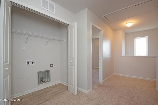 clothes washing area featuring washer hookup and light colored carpet