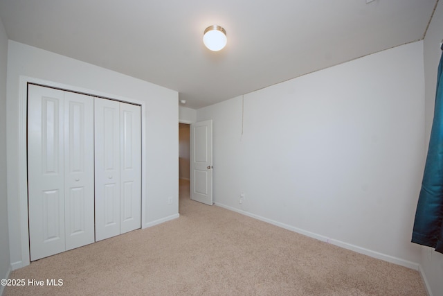 unfurnished bedroom featuring a closet and light colored carpet