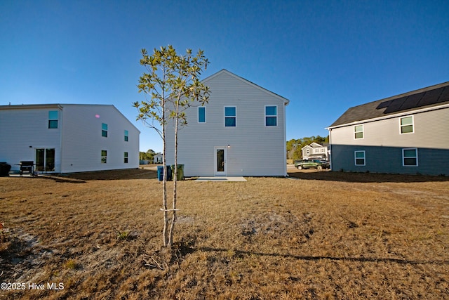 back of house featuring a lawn