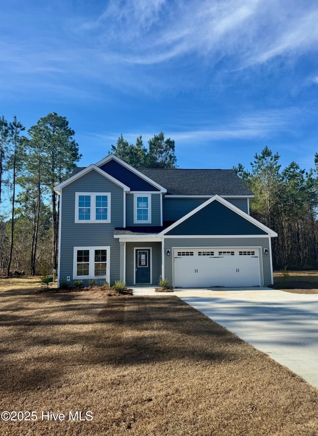 view of front facade featuring a front yard, an attached garage, and driveway