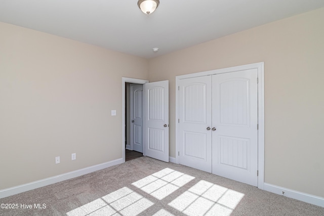 unfurnished bedroom with a closet and light colored carpet