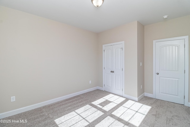 unfurnished bedroom with light carpet and a closet