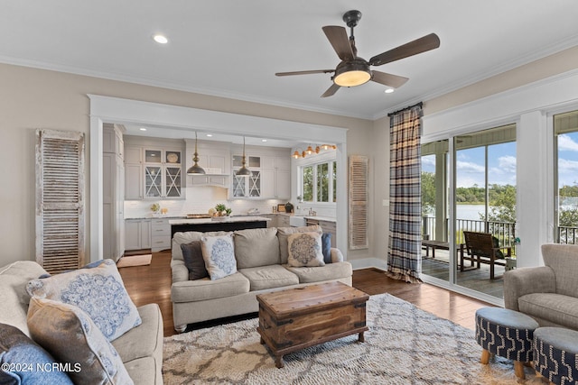 living area featuring dark wood-style floors, ornamental molding, a ceiling fan, and recessed lighting