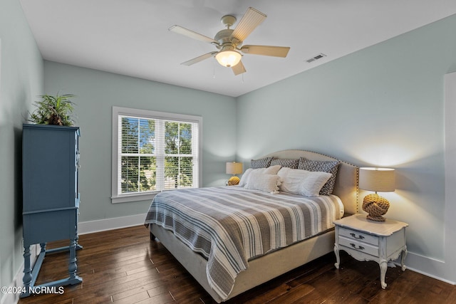 bedroom with visible vents, ceiling fan, baseboards, and hardwood / wood-style flooring