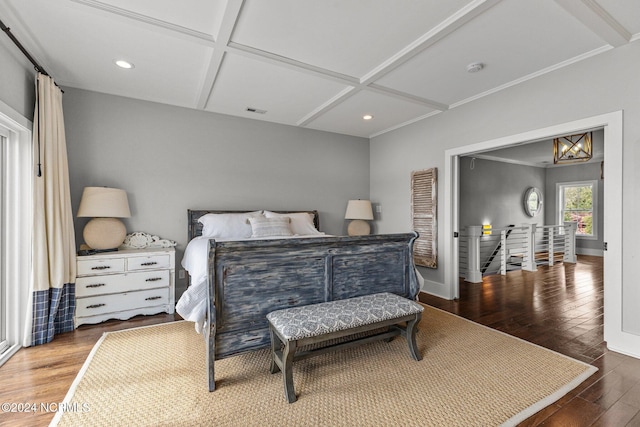 bedroom with coffered ceiling, wood-type flooring, and ornamental molding