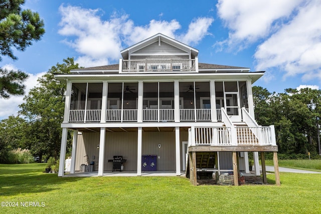 back of house featuring a lawn, a patio area, and a sunroom