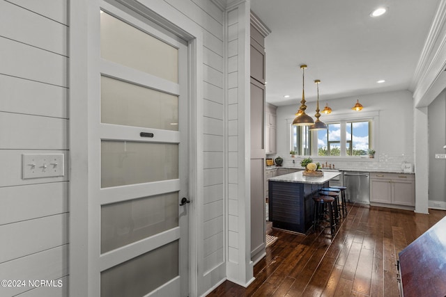 interior space featuring recessed lighting, dark wood-type flooring, light stone countertops, dishwasher, and a kitchen breakfast bar