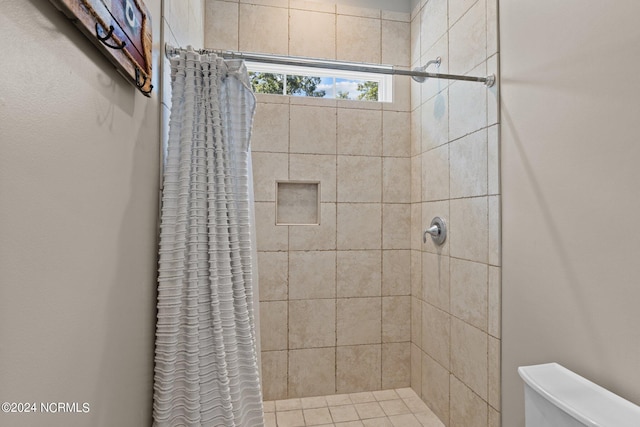 full bathroom featuring toilet and a tile shower