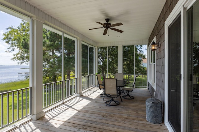 unfurnished sunroom with a water view and ceiling fan