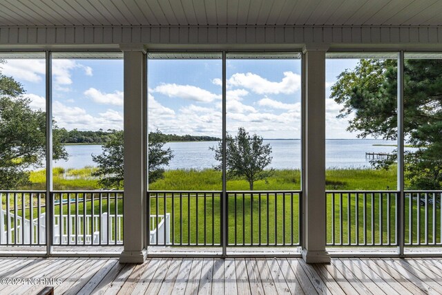 unfurnished sunroom featuring wood ceiling and a water view