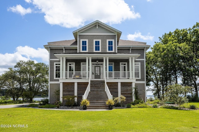 view of front of property with ceiling fan, a front yard, and a porch