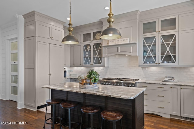 kitchen featuring dark wood-style floors, backsplash, a kitchen breakfast bar, and stove