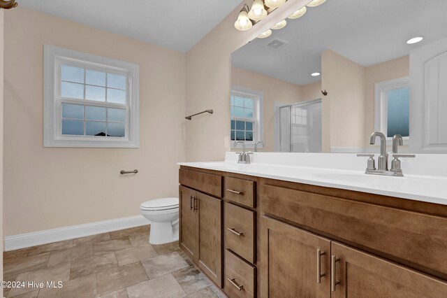 bathroom with an enclosed shower, vanity, and toilet