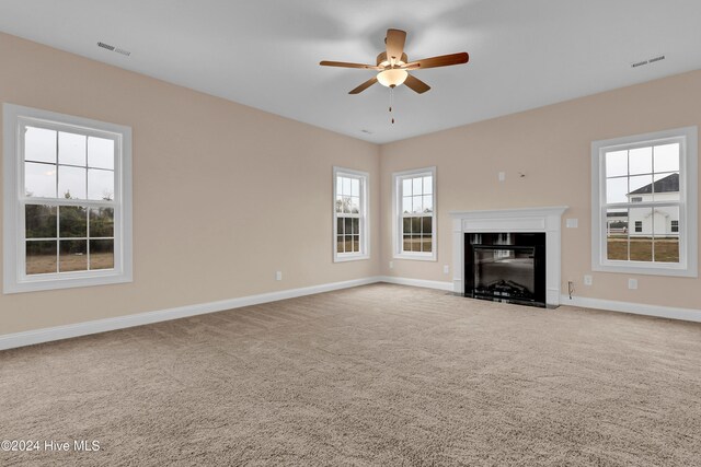 unfurnished living room with carpet and ceiling fan