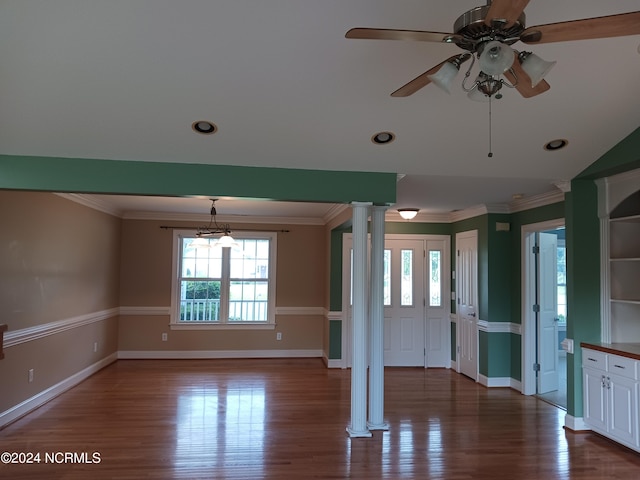 unfurnished living room with ceiling fan, ornamental molding, dark hardwood / wood-style flooring, and decorative columns