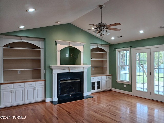 unfurnished living room featuring light wood-type flooring, vaulted ceiling, and ceiling fan