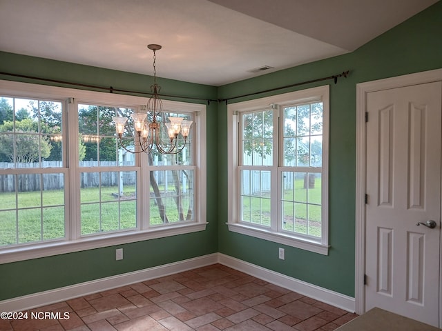 unfurnished dining area with a chandelier