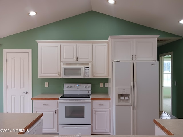 kitchen with lofted ceiling, white appliances, and white cabinets