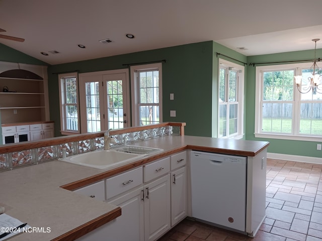 kitchen with white dishwasher, plenty of natural light, sink, and white cabinets