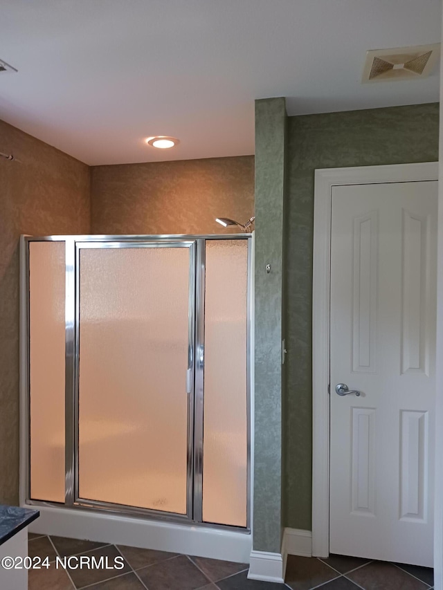 bathroom with vanity, walk in shower, and tile patterned flooring