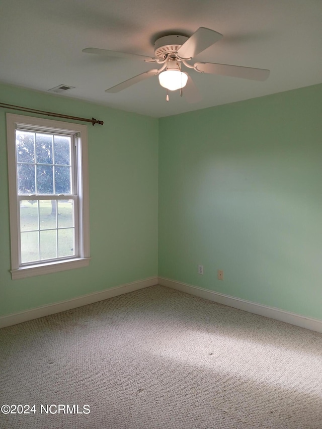 unfurnished room with plenty of natural light, ceiling fan, and carpet floors