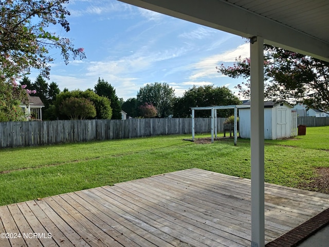 wooden deck featuring a lawn and a shed