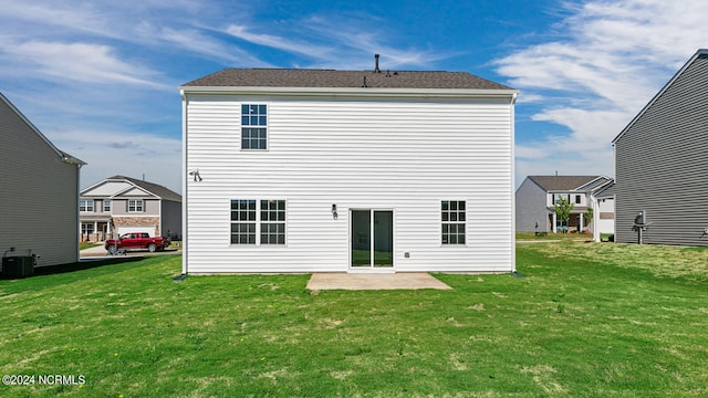 back of house with central air condition unit, a patio area, and a lawn