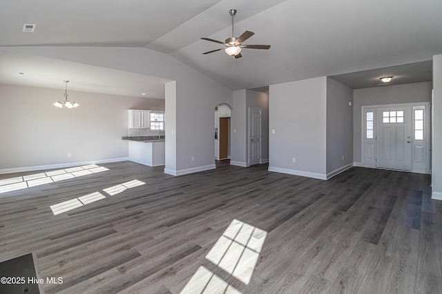 unfurnished living room featuring dark wood-type flooring, a healthy amount of sunlight, and ceiling fan with notable chandelier