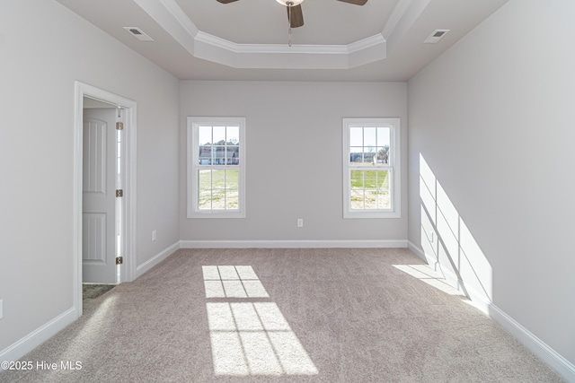 unfurnished room with a tray ceiling, ornamental molding, light colored carpet, and ceiling fan