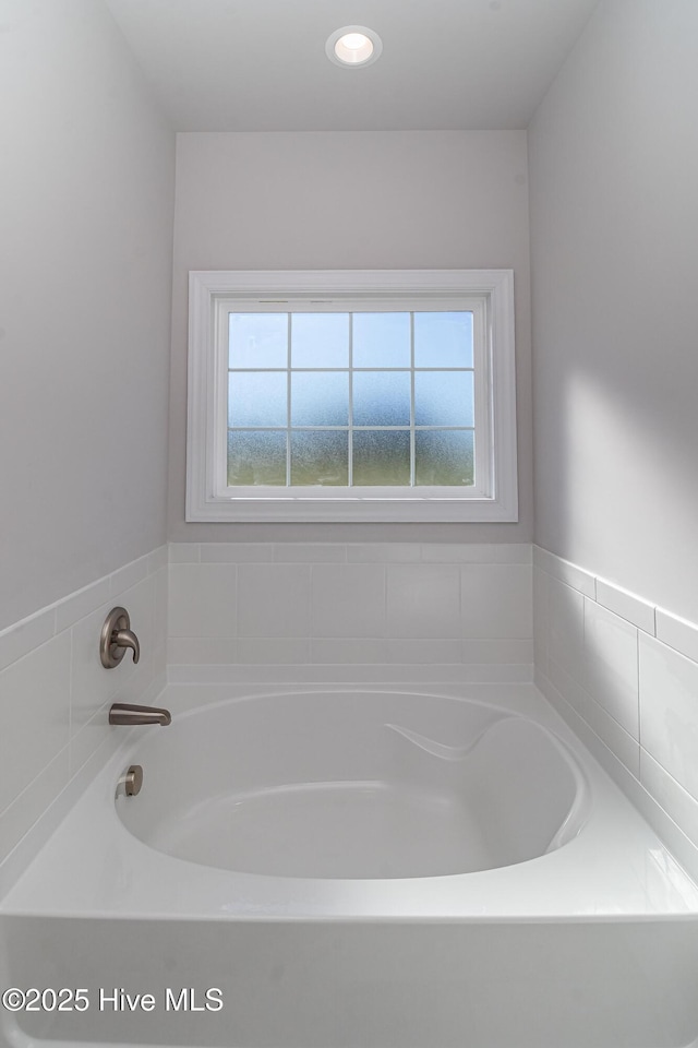 bathroom with a tub and a wealth of natural light