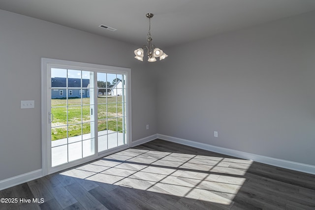 unfurnished room with hardwood / wood-style floors and a notable chandelier