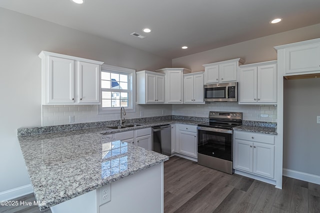 kitchen featuring appliances with stainless steel finishes, sink, white cabinetry, and dark hardwood / wood-style flooring