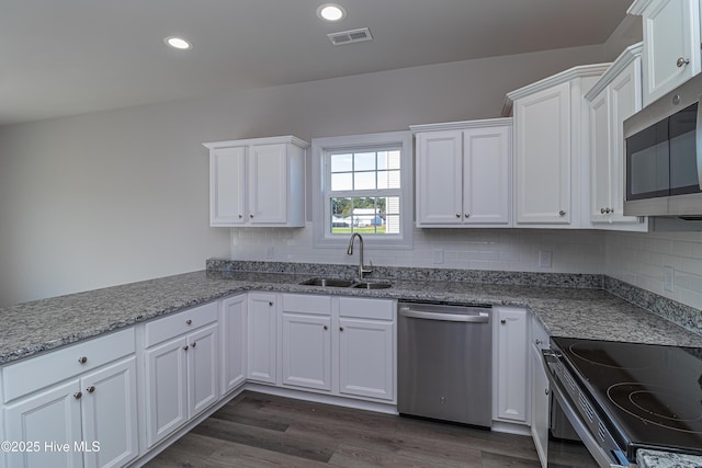 kitchen with sink, appliances with stainless steel finishes, white cabinetry, and decorative backsplash