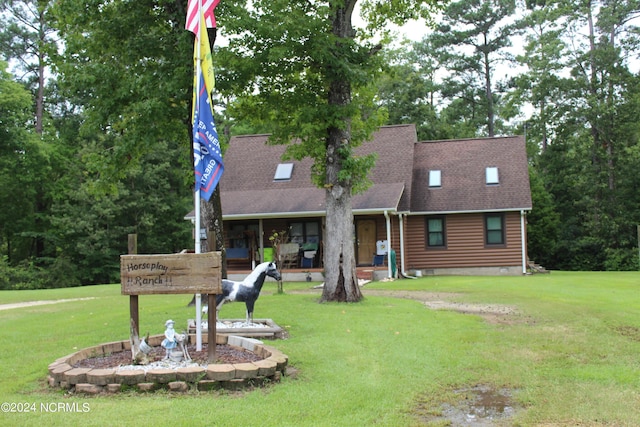 view of front facade with roof with shingles and a front yard