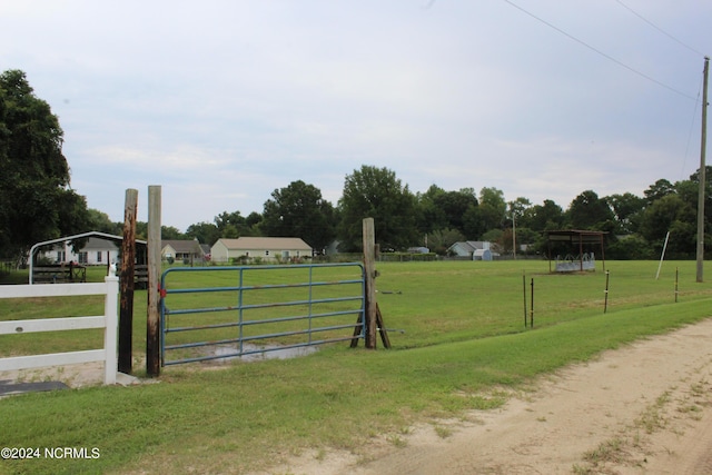 view of gate with fence and a lawn