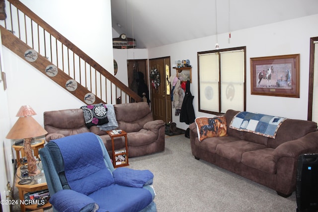 living room with carpet, stairs, and vaulted ceiling