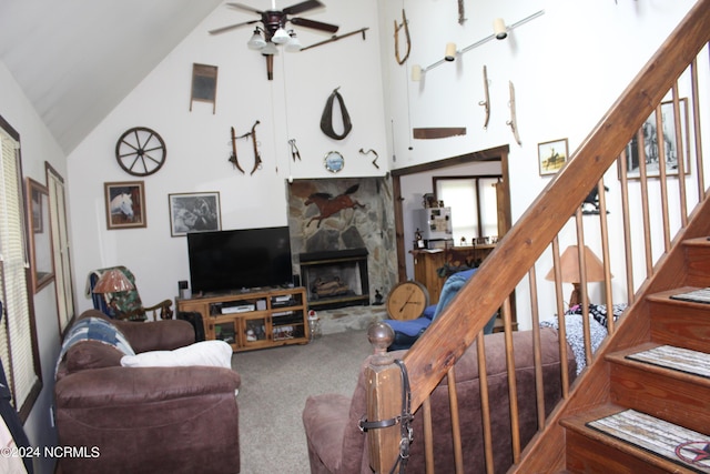 carpeted living area with stairs, high vaulted ceiling, a fireplace, and a ceiling fan