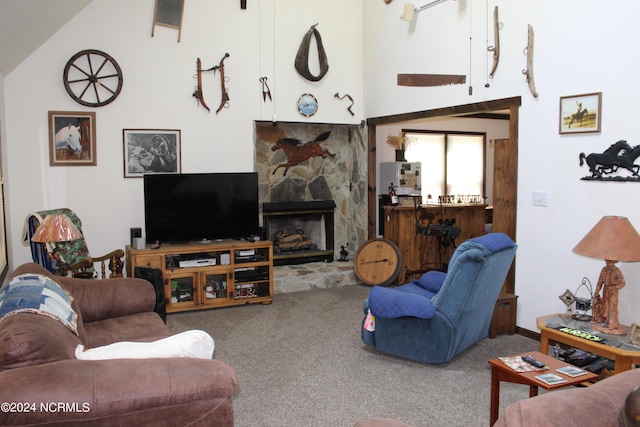 carpeted living area with a stone fireplace and a high ceiling