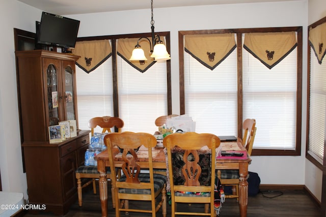 dining space with a chandelier, dark wood-style flooring, and baseboards