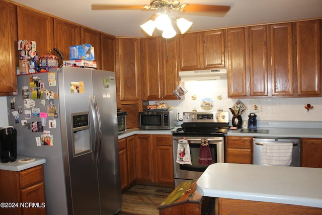 kitchen featuring stainless steel appliances, light countertops, and under cabinet range hood