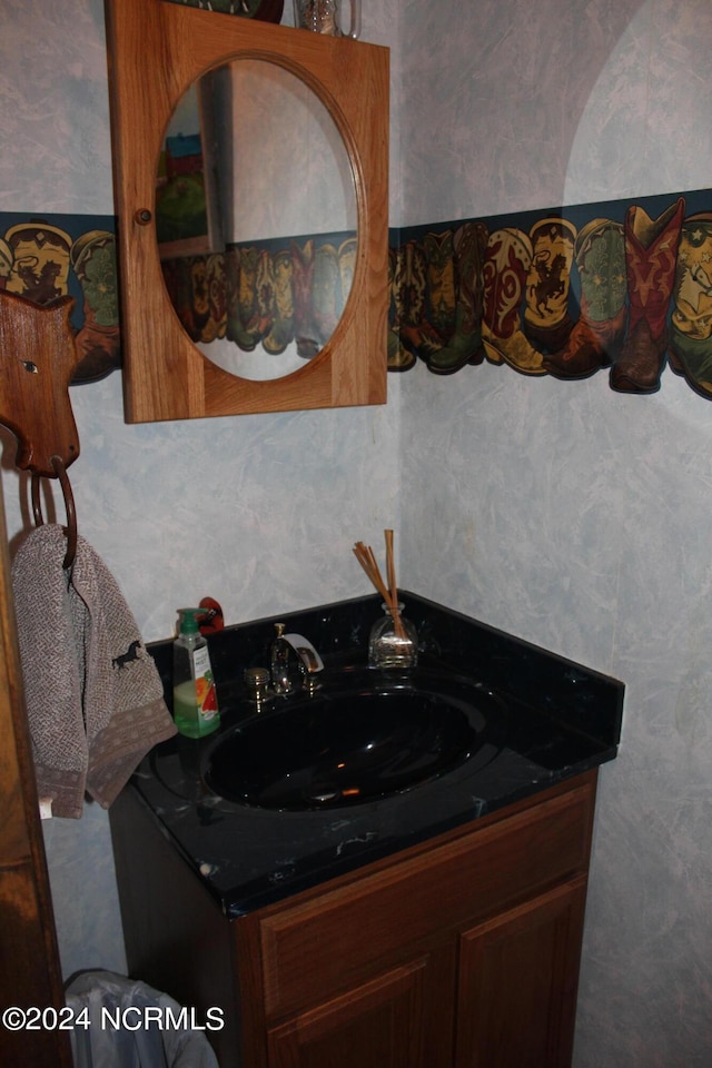 bathroom featuring vanity and wallpapered walls