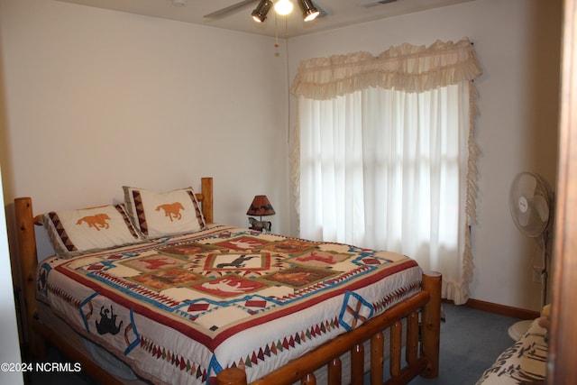 bedroom with dark colored carpet, multiple windows, visible vents, and baseboards