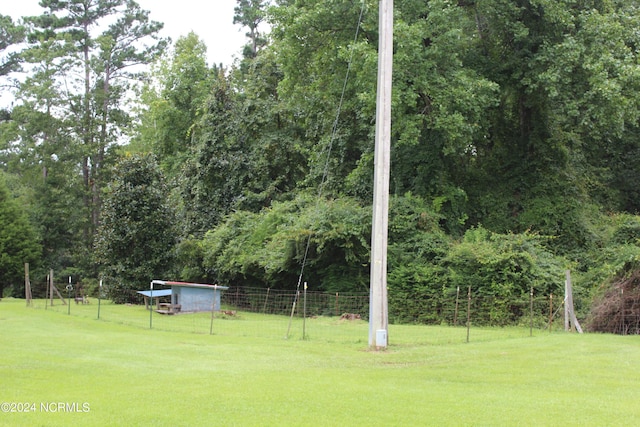 view of yard with a forest view and fence